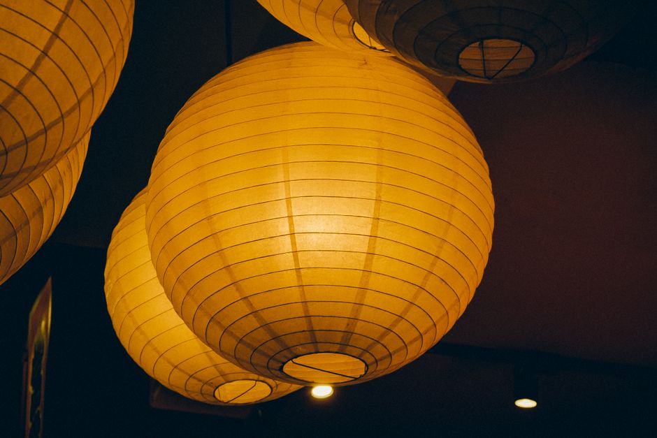 Warm paper lanterns create a cozy atmosphere with soft, ambient lighting indoors.