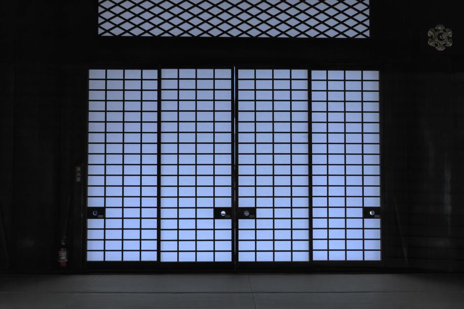 Elegant view of a traditional Japanese shoji door with soft lighting, creating a serene indoor atmosphere.